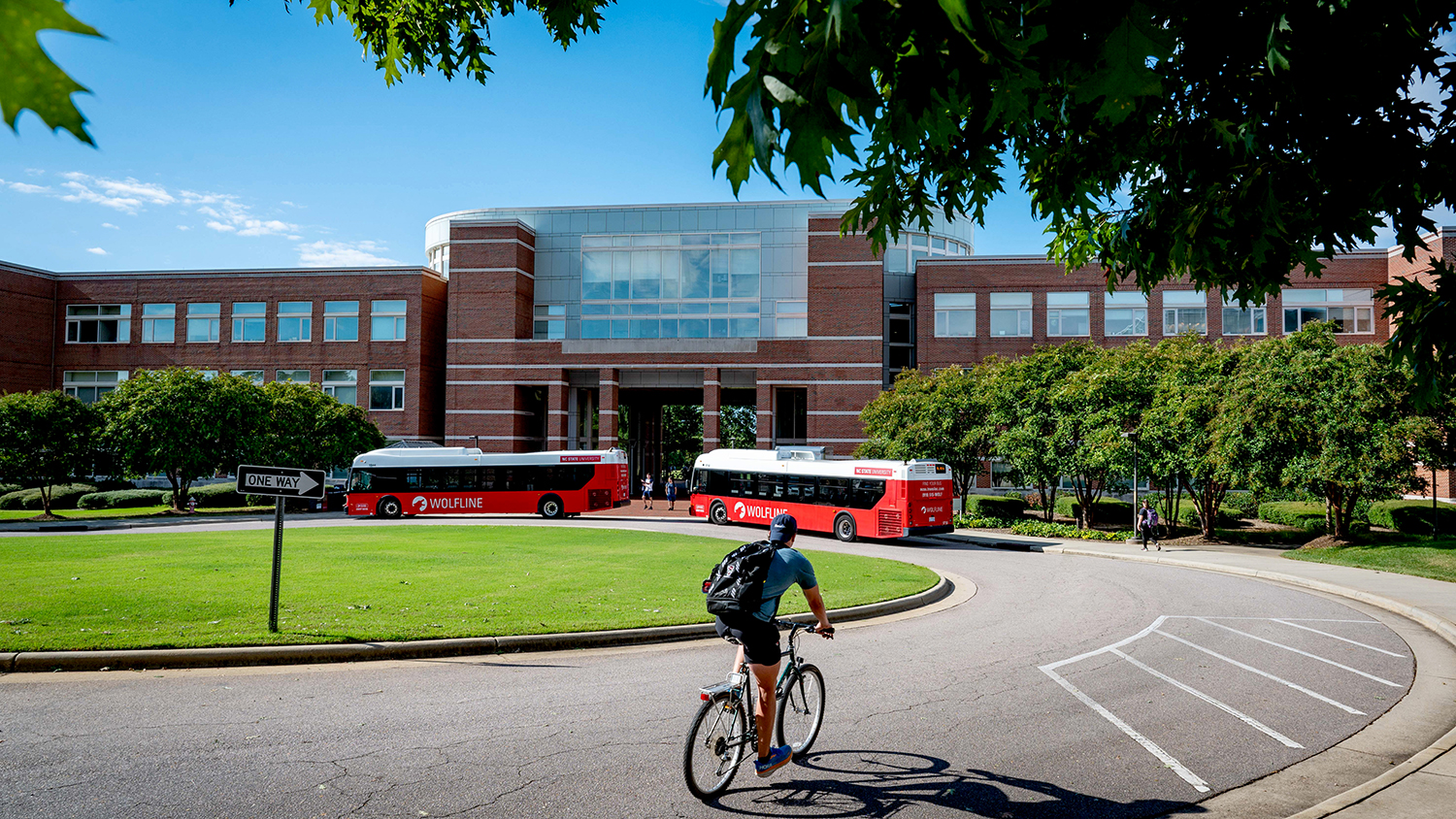 Students arrive at Engineering Building II in various forms of transportation on a late summer morning.