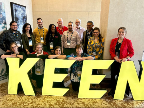 College of Engineering participants of the 2023 Wolfpack Engineering Unleashed Incubator pose for a group photo while standing behind large yellow letters spelling out KEEN.
