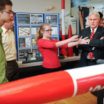 Alyssa Doman, a member of the NC State Rocketry Team, shows the chancellor some of the club's work.