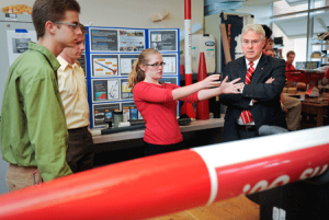 Alyssa Doman, a member of the NC State Rocketry Team, shows the chancellor some of the club's work.