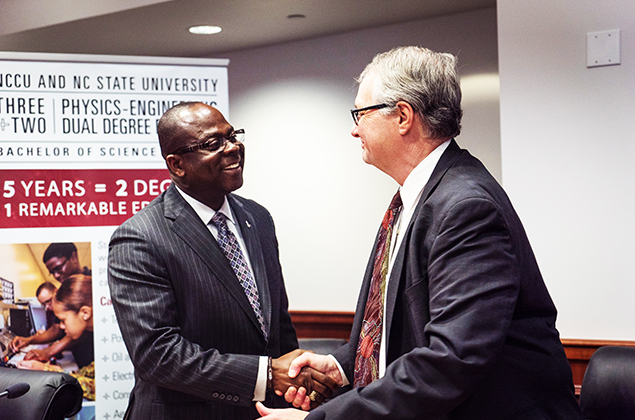 Dr. Johnson Akinleye, left, provost and vice chancellor for academic affairs at NC Central, shakes hands with Dr. Warwick Arden, provost and executive vice chancellor at NC State.