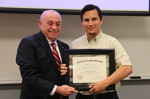 Dr. Joseph DeCarolis, right, accepts his Alcoa award from Dr. Louis A. Martin-Vega.