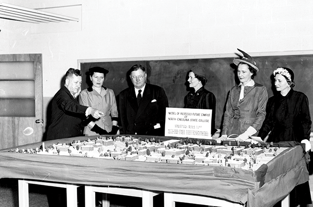 Using a model on display in Riddick Engineering Laboratories in 1949, Colonel John William Harrelson (far left), then-chancellor of North Carolina State College, shares future plans for the campus.