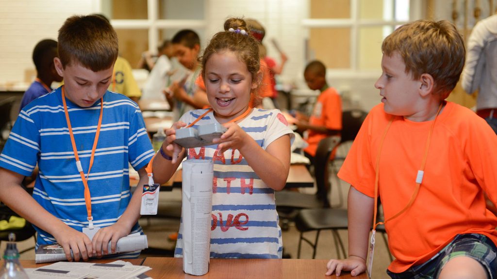 Elementary school campers making chairs from newspaper.