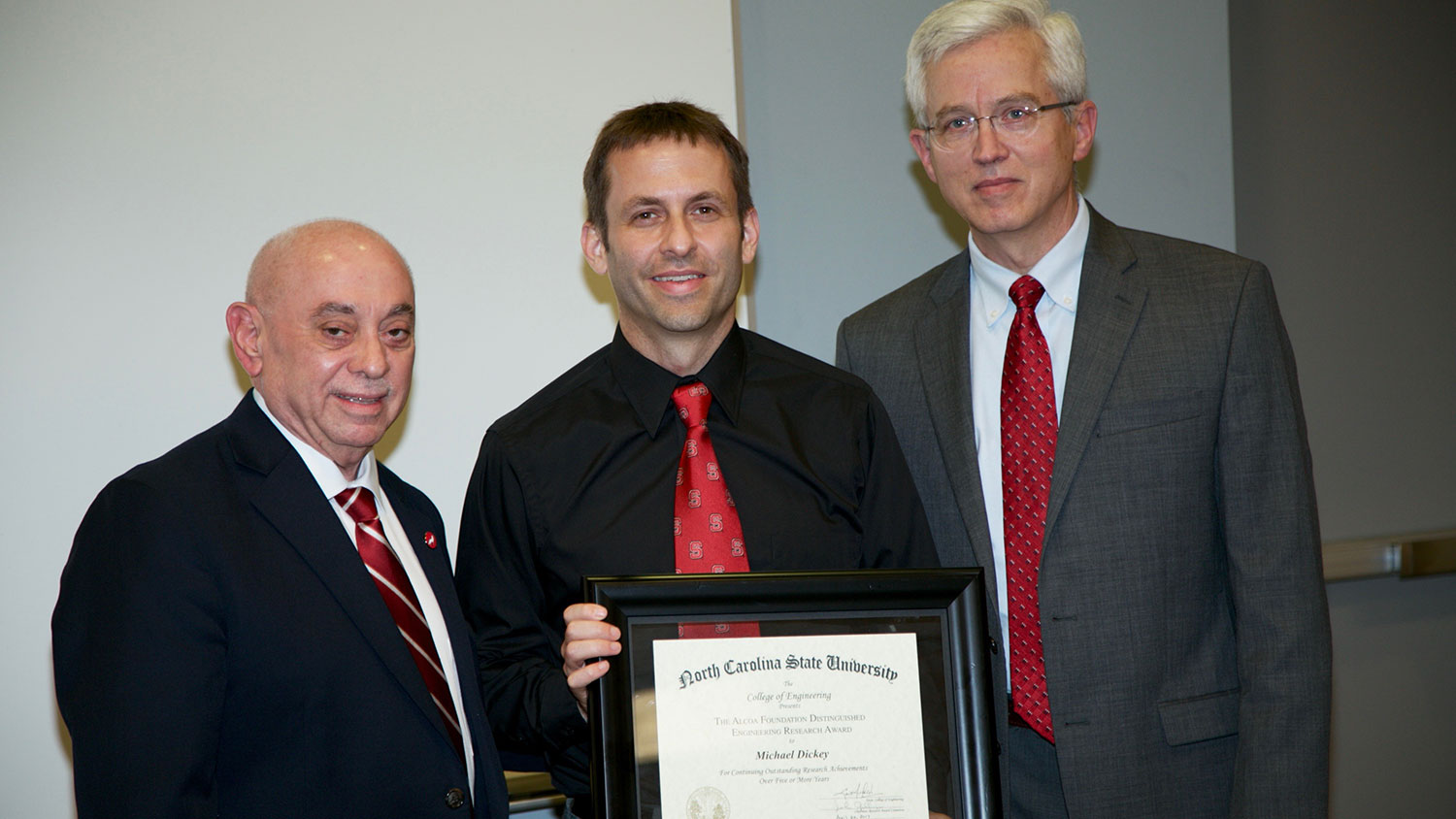 Dr. Michael Dickey, professor of chemical and biomolecular engineering, receives the Alcoa Foundation Distinguished Engineering Research Award from Dr. Louis Martin-Vega, dean of the College of Engineering, and Dr. Douglas Reeves, associate dean of graduate programs for the College.