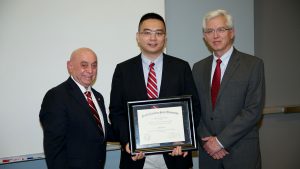 Dr. Zhen Gu (center), associate professor of biomedical engineering, receives the Alcoa Foundation Engineering Research Achievement Award from Dr. Louis Martin-Vega (left) and Dr. Douglas Reeves.