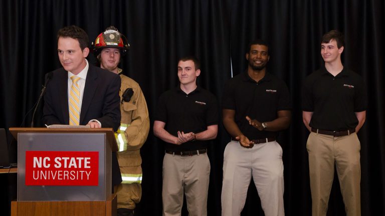 Host of the award ceremony, WRAL's Brian Schrader, speaks about the winning team of design day, PulseAware, a firefighter heart monitor. (Photo: Robert Lasson, 2017)