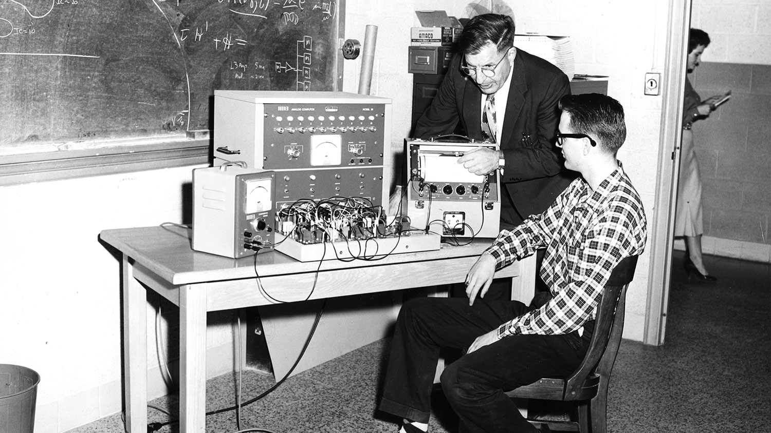 In this photo, taken in December 1956, Dr. John Cell shows student James Wallace how to operate a Donner Model 30 analog “computor.”