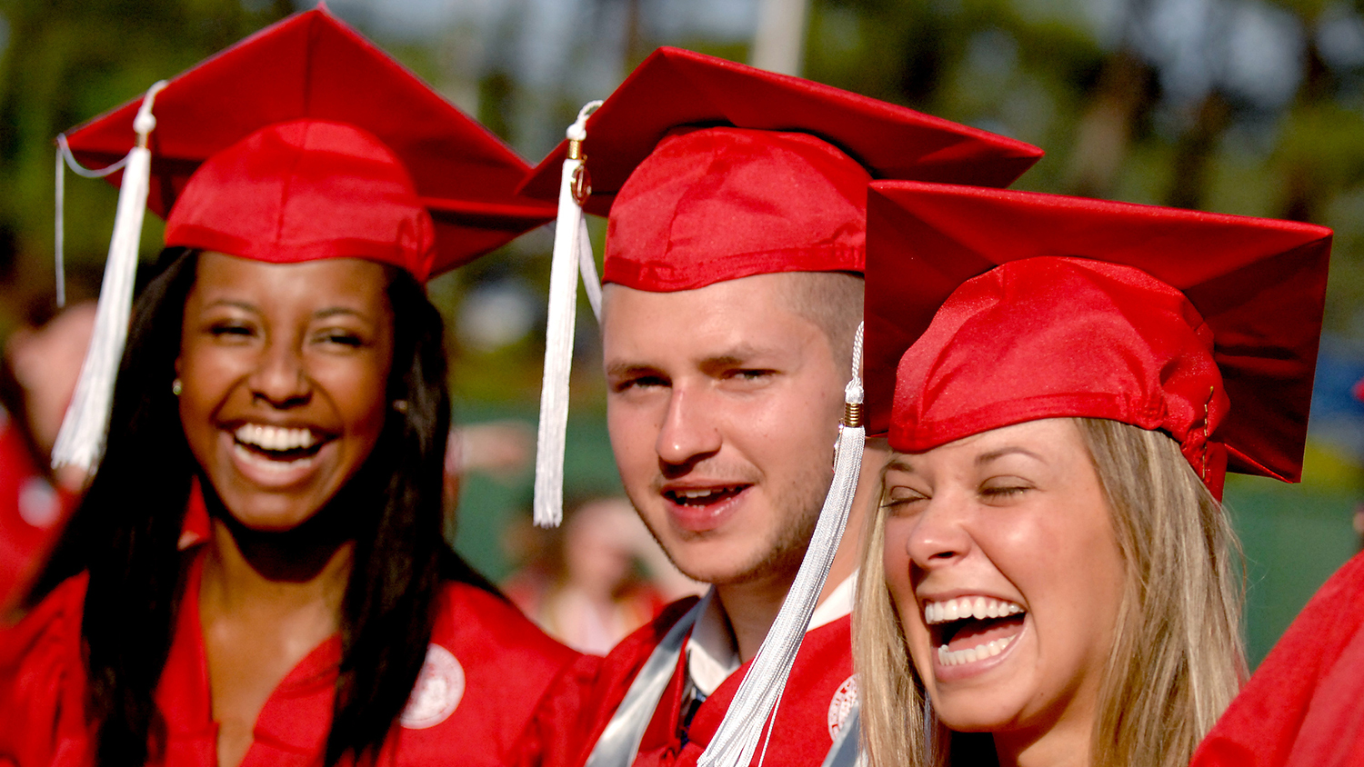 three students in caps and gowns