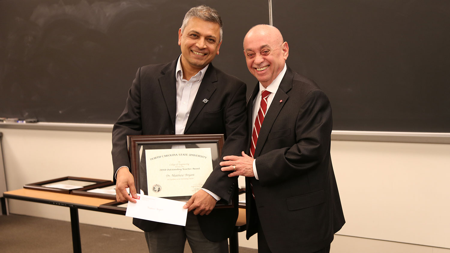 MAE department head Dr. Srinath Ekkad accepts the award from Dean Louis Martin-Vega on Bryant’s behalf.