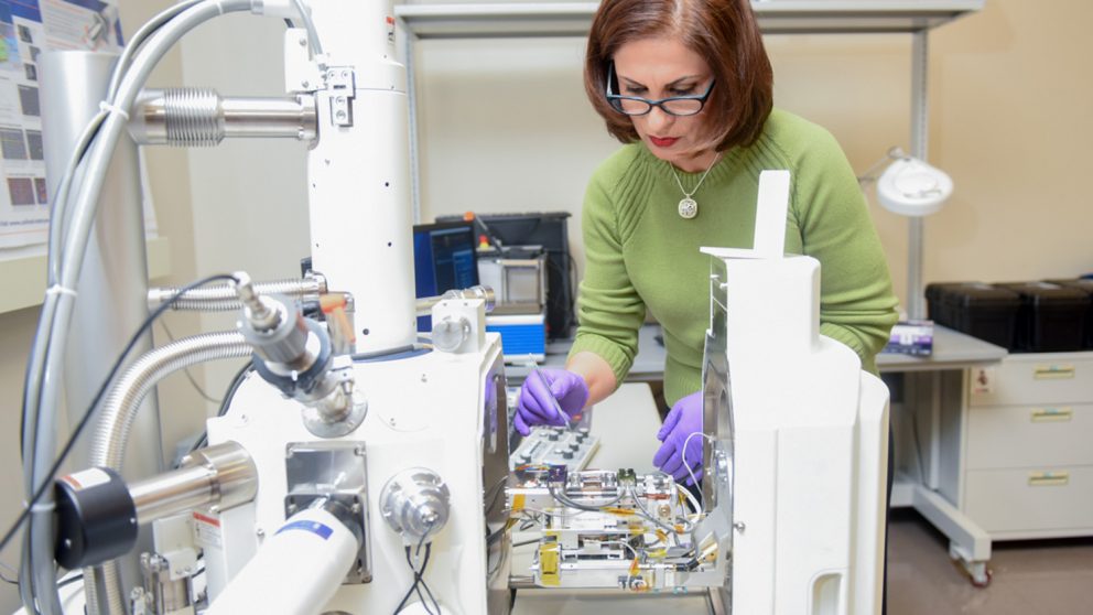 Afsaneh Rabiei is pictured here with the device she developed that can capture scanning electron microscopy (SEM) images in real time at temperatures up to 1,000 degrees Celsius while applying stresses as high as two gigapascal.