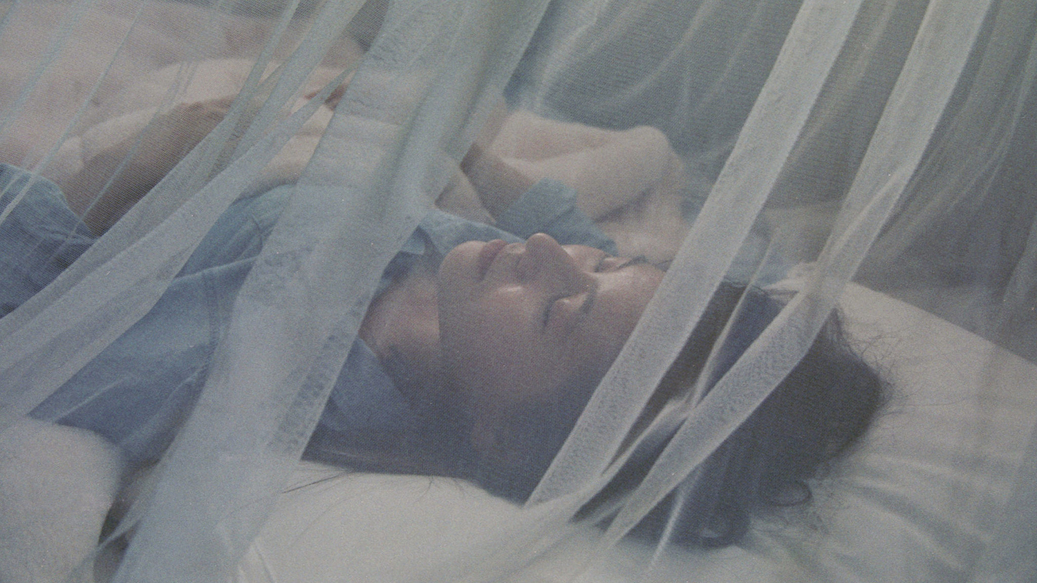 Woman sleeping under mosquito net.