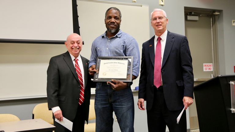 Dr. Cranos Williams, center, accepts the Alcoa Foundation Engineering Research Achievement Award from Dr. Louis Martin-Vega, left, and Dr. John Gilligan.