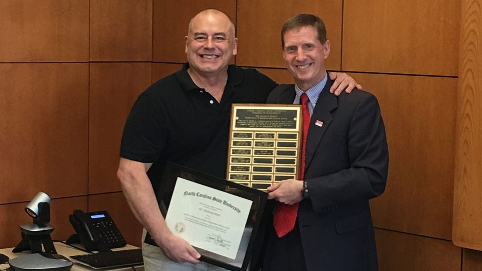 Dr. Jerome Lavelle, right, presents the George H. Blessis Outstanding Undergraduate Advisor Award to Dr. Medwick Byrd.