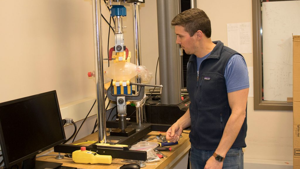 Landon Grace, an assistant professor of mechanical and aerospace engineering at NC State University, works with the emergency ventilator prototype (Photo by NC State University)