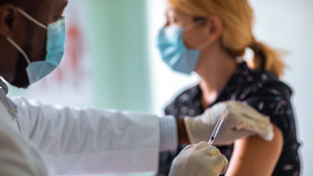 masked patient receiving injection