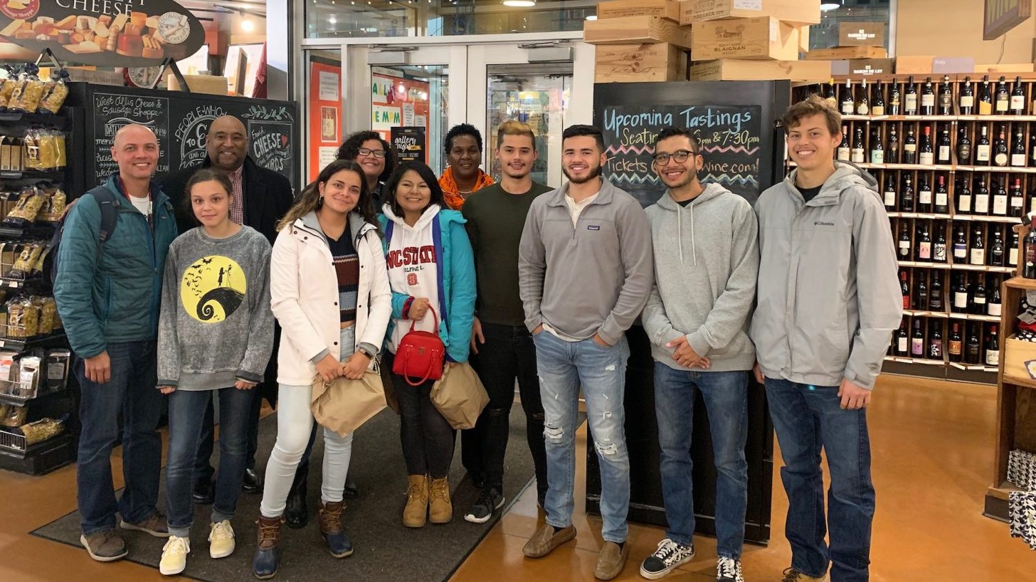 Group of students posing together in specialty grocery store.