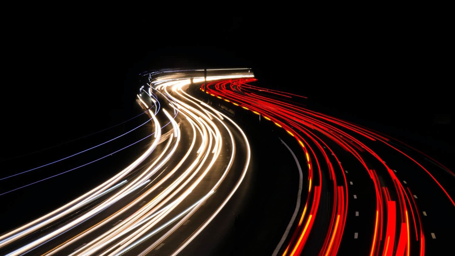 Night-time photo shows two lines of traffic, one moving toward the camera, and one moving away from the camera.
