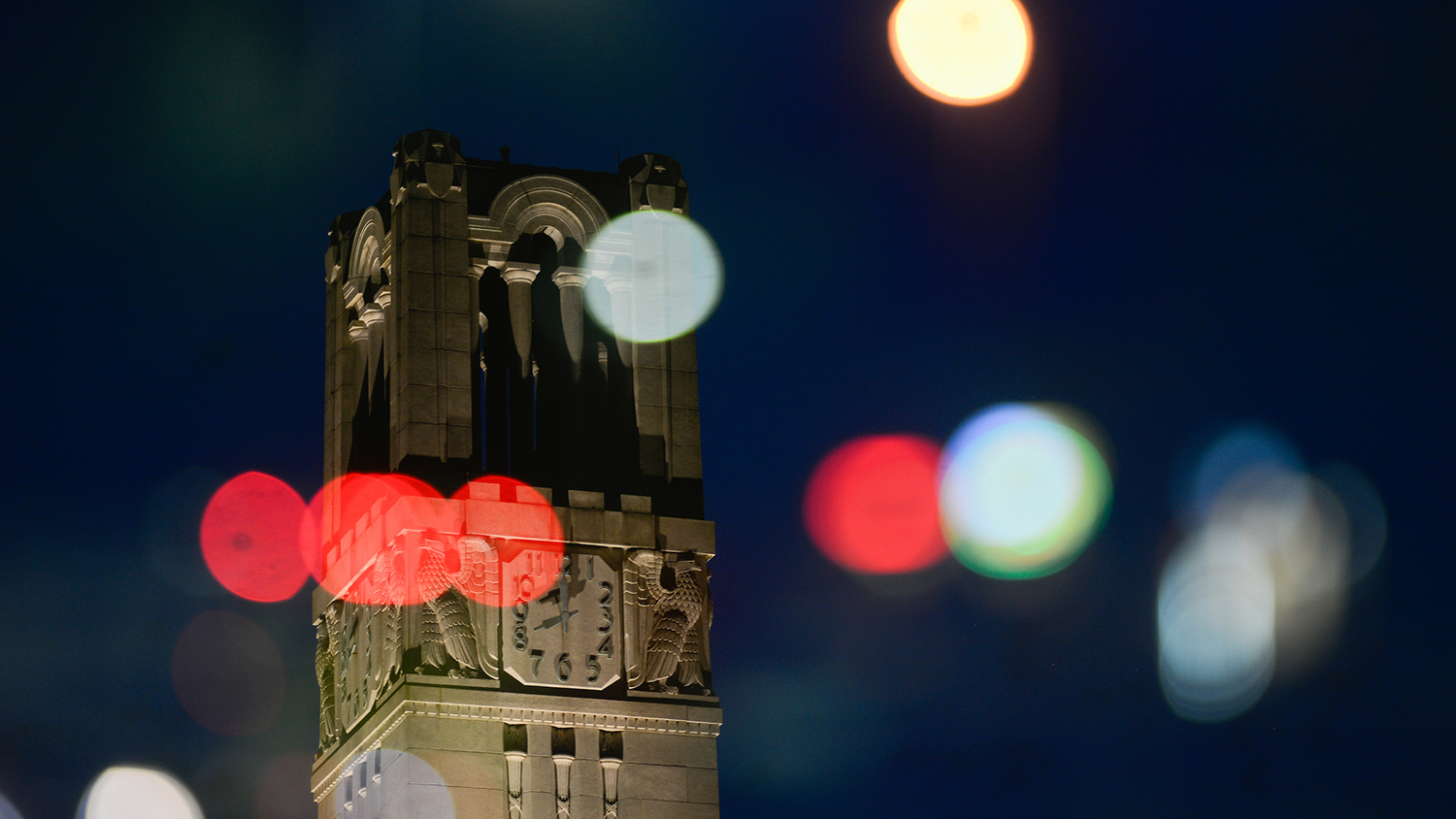 The NC State Belltower at dusk and night.