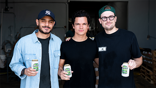 From left, Gabriel Gonzalez, Gustavo Darquea G. and Ricardo Sucre. All three are holding a soda-style can of Casalu; the can has varying shades of green and yellow text and graphics on a background of white.