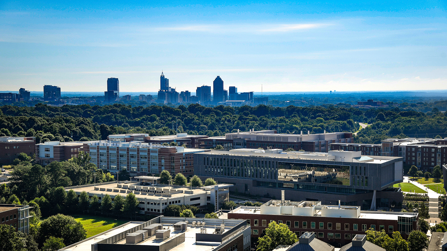 Mid morning aerial view of College of Engineering Centennial Campus. Fitts-Woolard Hall is in the foreground and the Raleigh skyline is in the background.