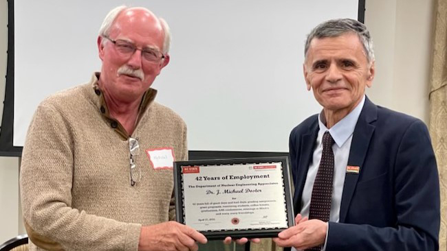 Nuclear engineering department head Kostadin Ivanov, right, presents J. Michael Doster with plaque commerating his years with NC State University.