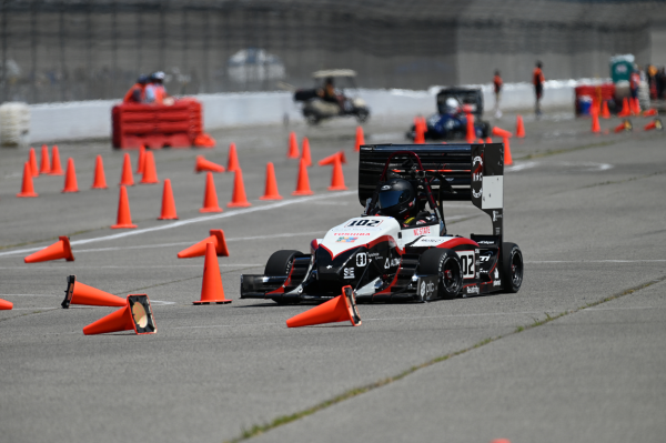 NC State Formula SAE car in competition driving through traffic cones.