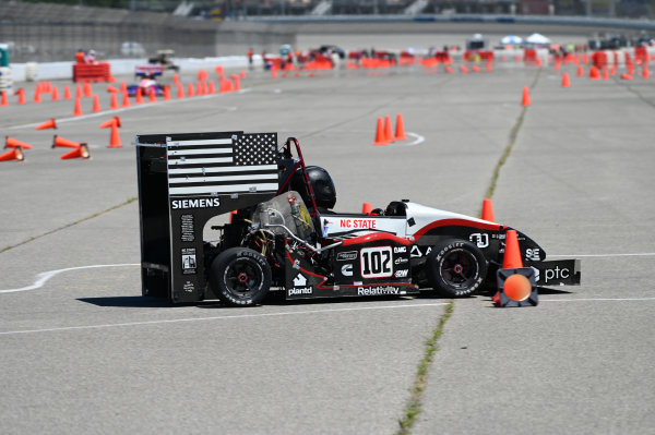 NC State Formula SAE car in competition driving through traffic cones.