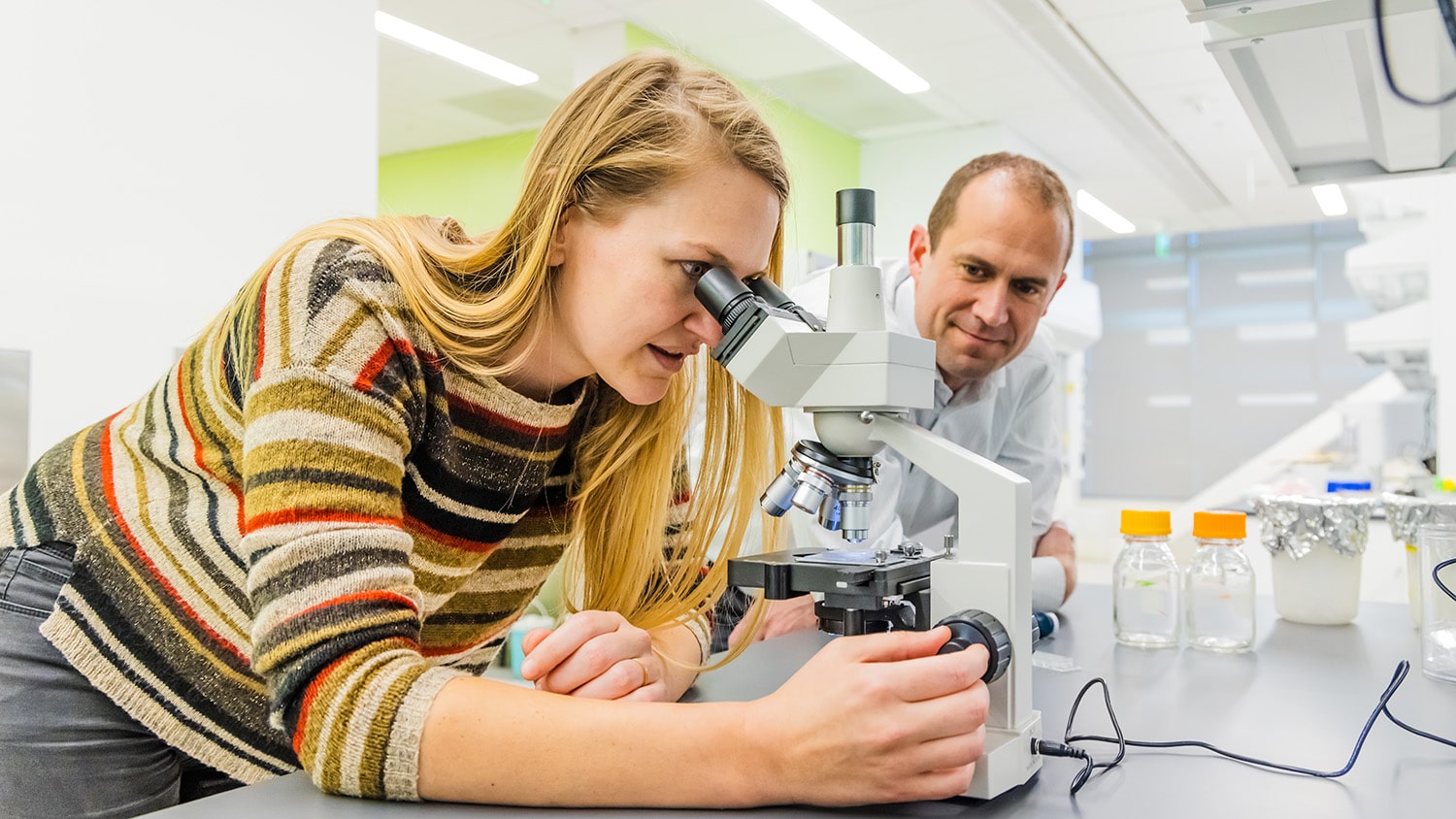 Postdoctoral researcher Lisa Van den Broeck, left, evaluates 3D bioprinted plant cells before STEPS Center director Jacob Jones, right, examines them.