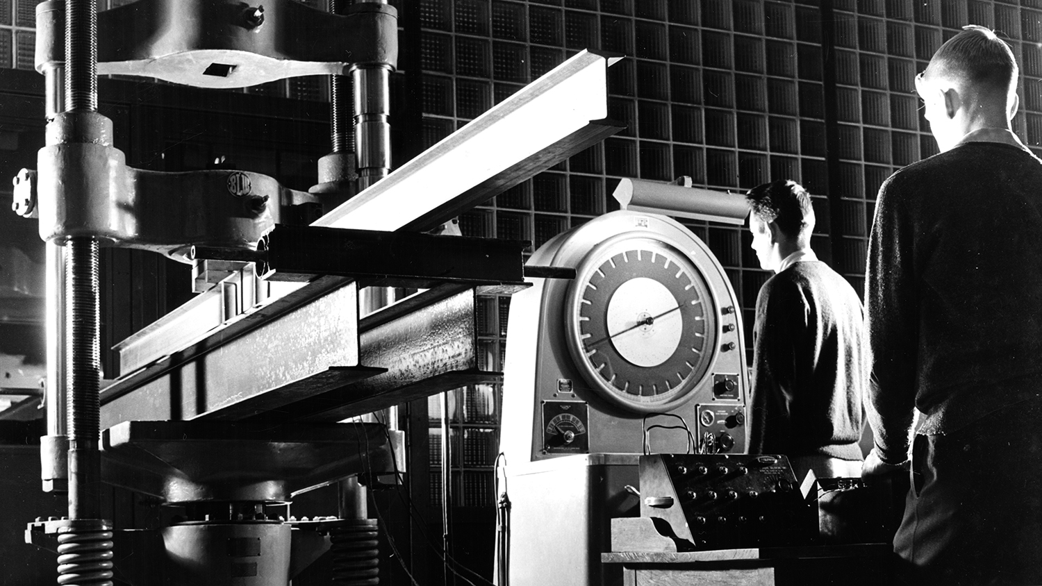Archival black and white photo of two NC State staff members working in an early lab.