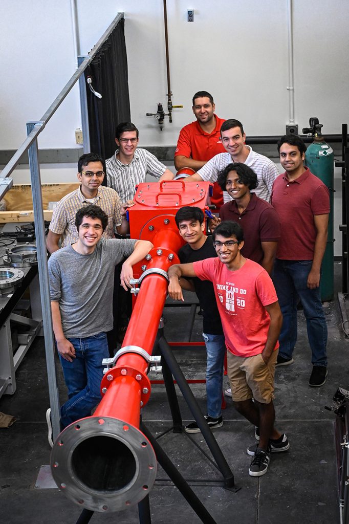 From left, Liam Stumbar, Venkateswaran Narayanaswamy, Chase Jenquin, James Walz, JW Mason, Jerod Schwandt, Ashwin Sivayogan, Victor Ibarra Mendoza and Shaan Stephen standing around the subscale model of the hypersonic tunnel.