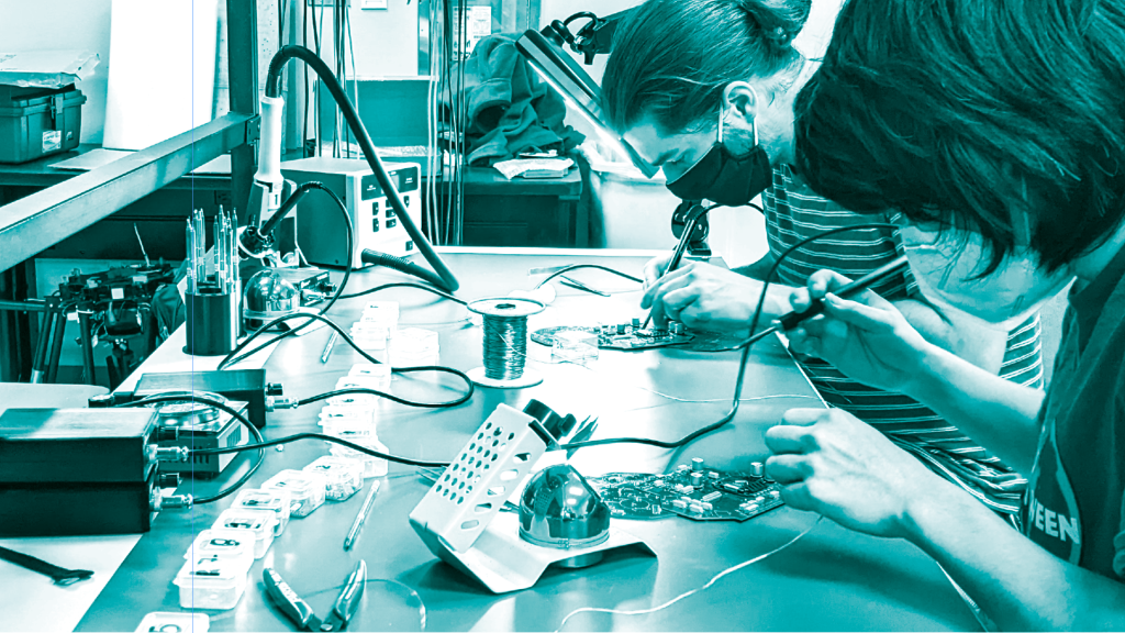 Students work on drones at lab table.