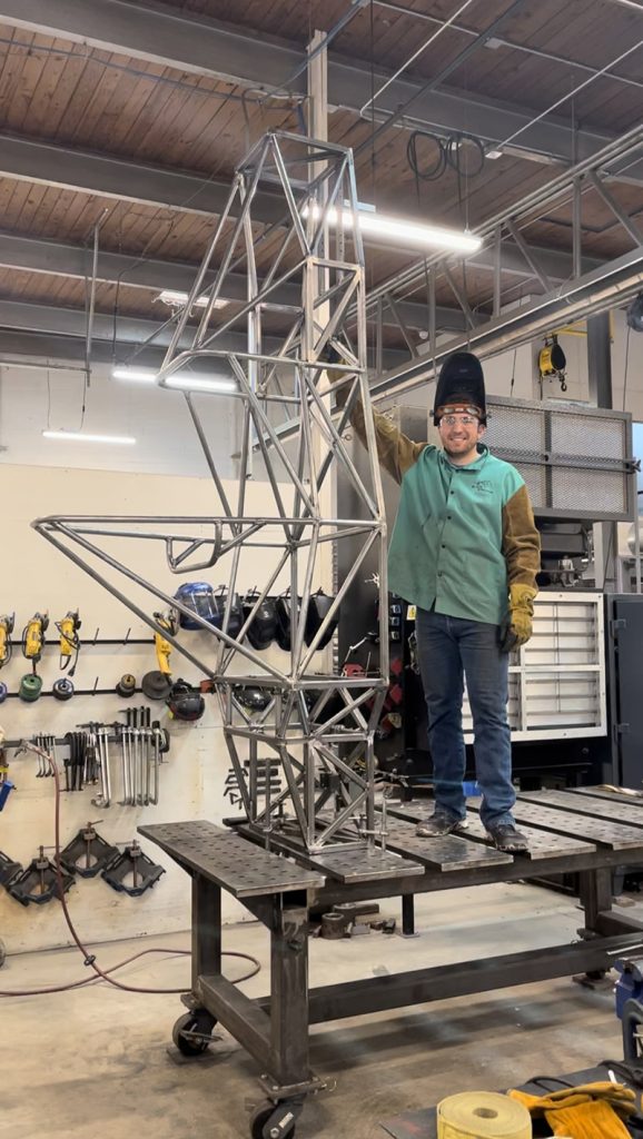 Robert Brenneman poses next to a scaffolding.