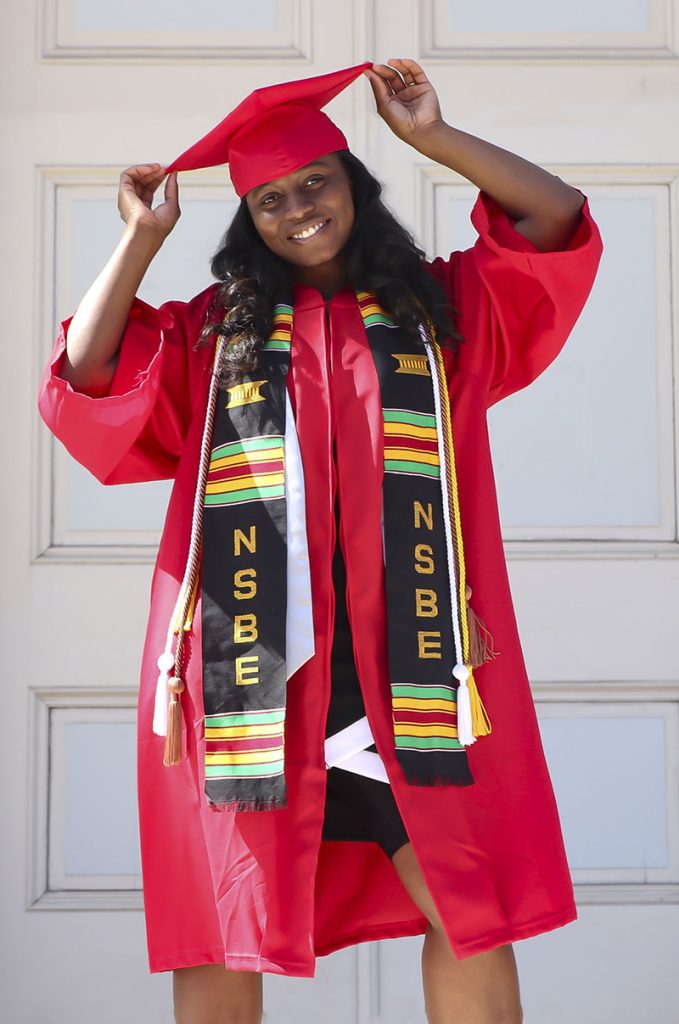 Tabitha Gardner dressed in a red graduation cap and gown.