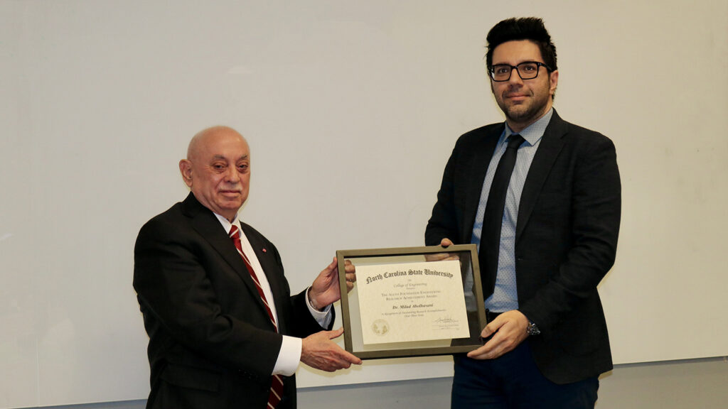 Dean Louis Martin-Vega presents the Alcoa Engineering Research Achievement Award to Milad Abolhasani, right.