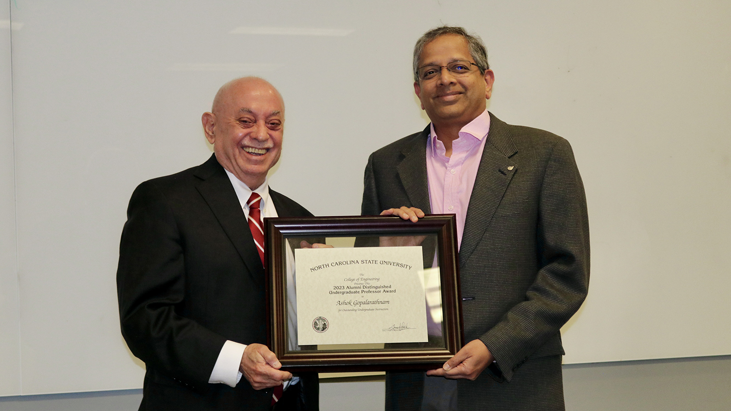 Dean Louis Martin-Vega, left, presents Ashok Gopalarathnam with the Alumni Distinguished Undergraduate Professor Award.