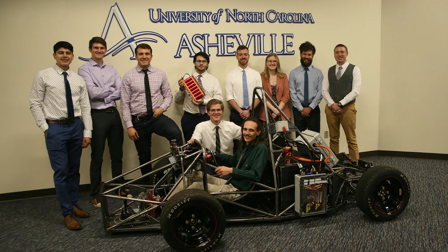 Joint NC State/UNC Asheville mechatronics engineering students pose with the electric vehicle they built from scratch.