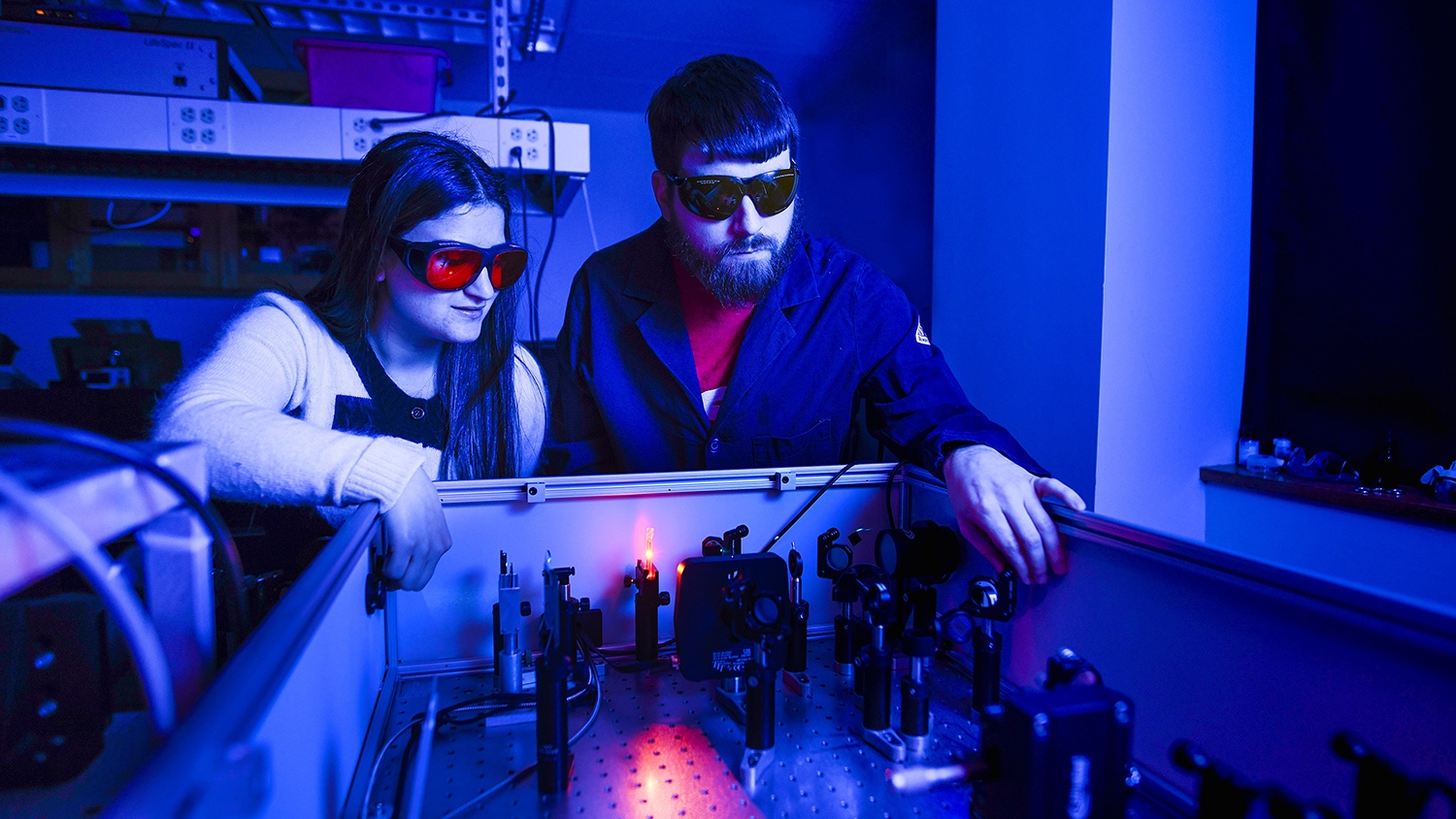 Students wearing protective goggles work in a laser lab on Centennial campus.