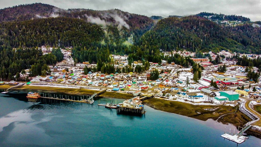 An aerial shot of Hoonah, a primarily native Tlingit community in Alaska. Image shows a populated area next to a body of water.