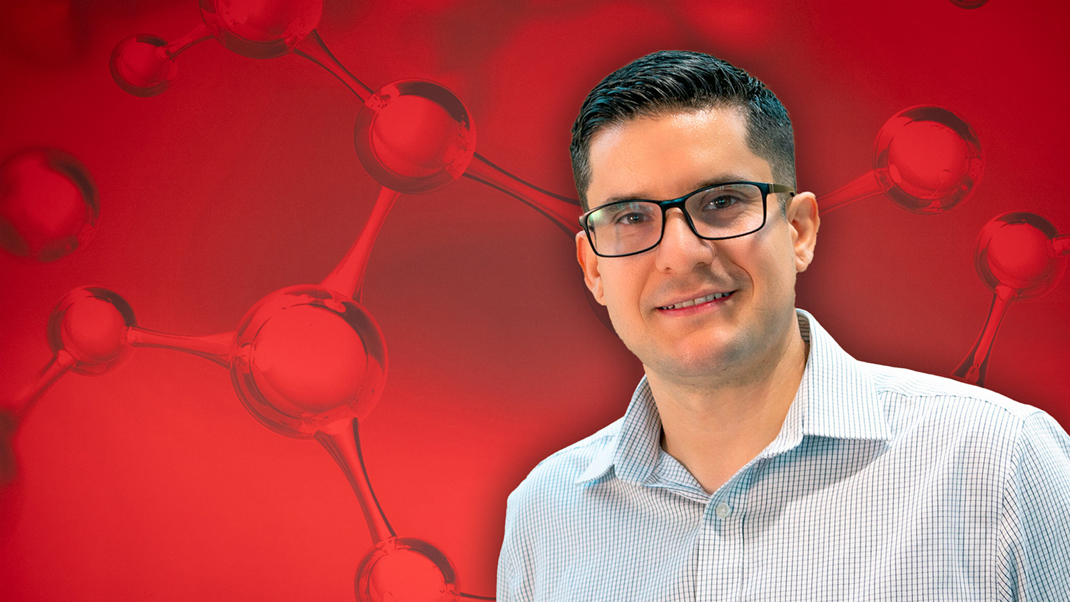 Adolfo Escobedo wearing glasses and white shirt with a light blue grid design in front of a red background showing enlarged molecular structures.