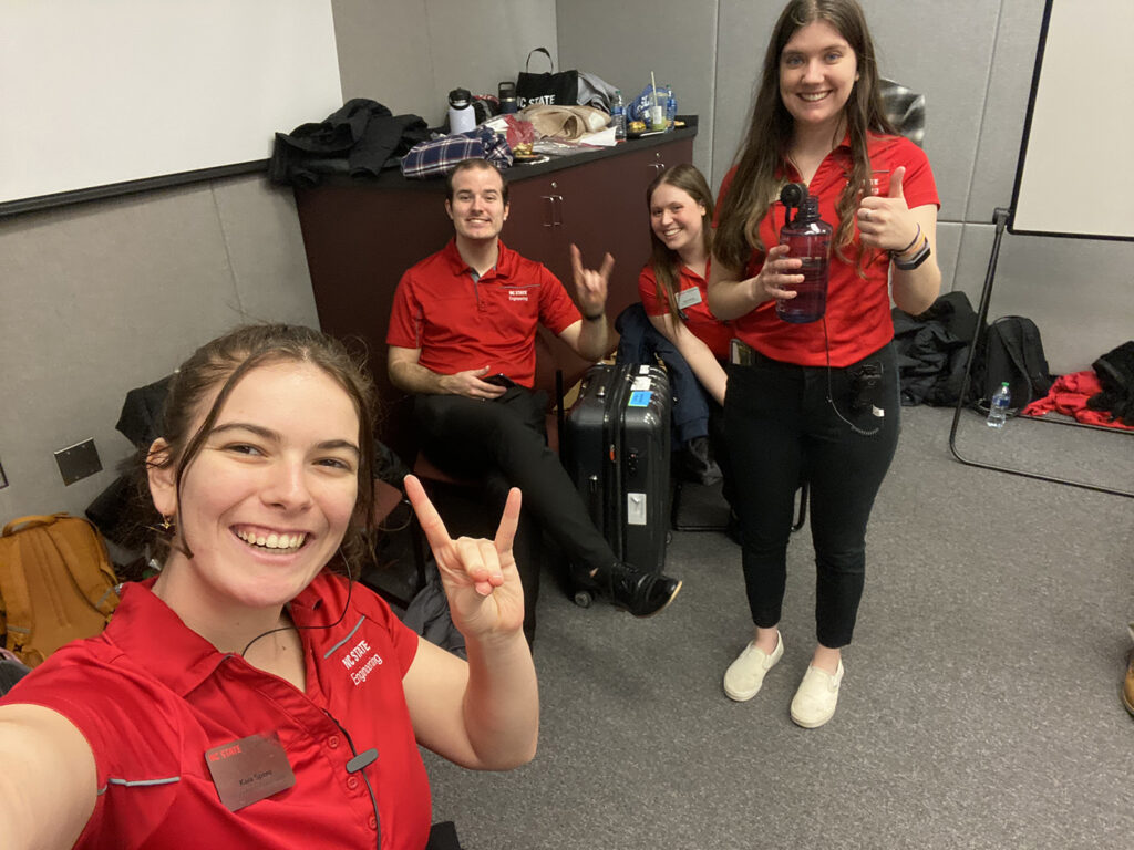 Kaia Spero with a group of three other Engineering Ambassadors. Each are wearing NC State red polo shirts with the NC State Engineering logo and name tags.