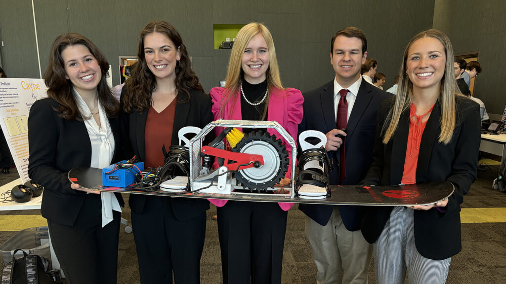 Kaia Spero, second from left, stands with a group of four other students holding a modified snowboard.