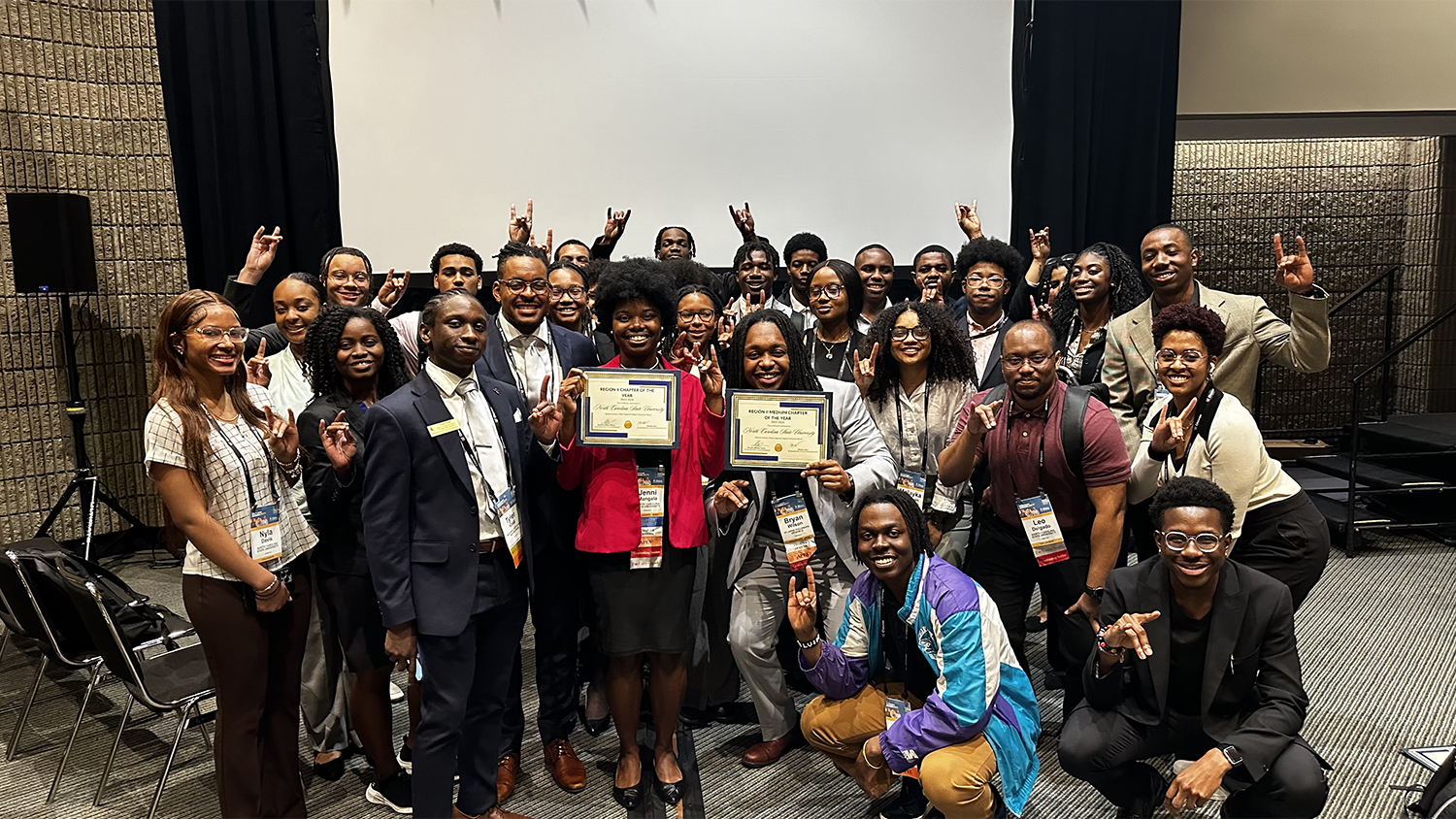 The NC State NSBE chapter pose after winning two awards. Jenni Mangala, center left, and Bryan Washington, center right, hold the awards.