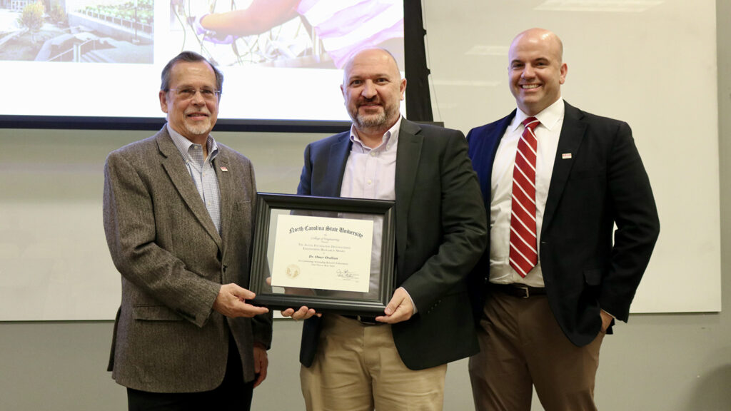 Omer Oralkan, center, receives the Alcoa Foundation research award from, left, Peter Fedkiw, interim associate dean for research and infrastructure, and Jim Pfaendtner, Louis Martin-Vega Dean of Engineering.