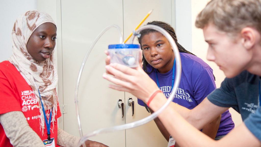 High school campers build pumps at camp.