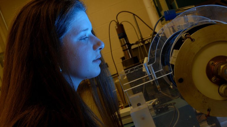 Nuclear engineering student checks on plasma experiment.