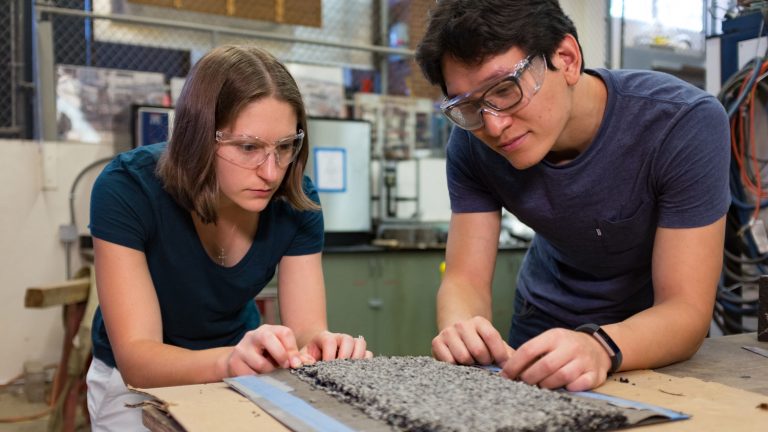 Dr. Cassie Castorena and Ph.D. student Kangjin Lee examine a chip seal used for pavement preservation.