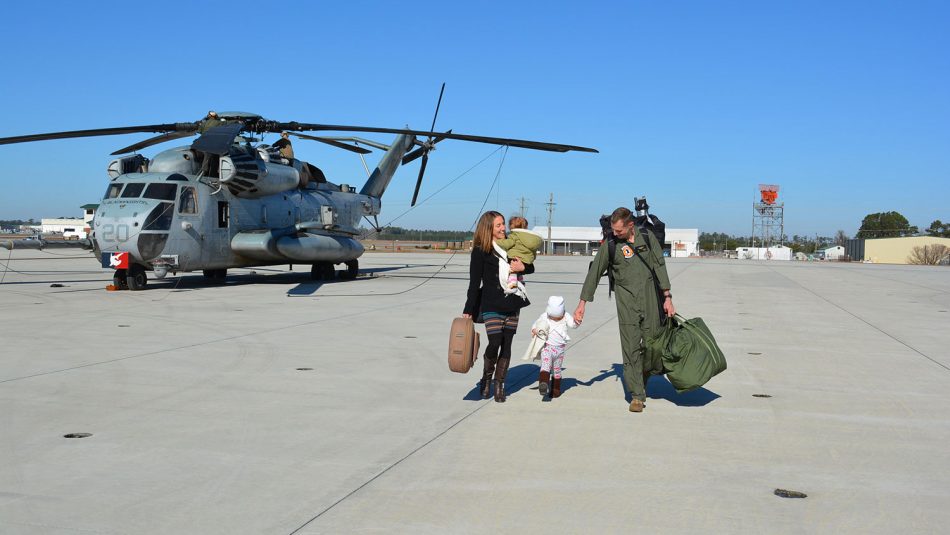 Soldier meets wife and two children on the tarmac.