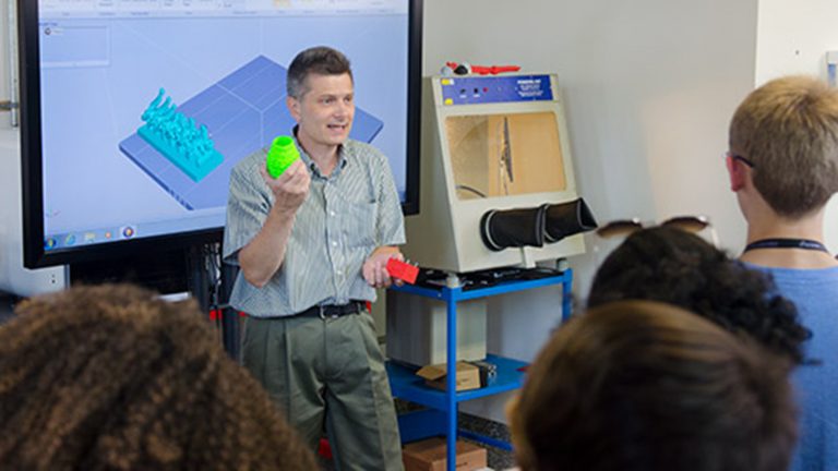 Lecturer Jason Low talks with students from the NC School of Science and Mathematics about the 3D-printing lab in the ISE department.